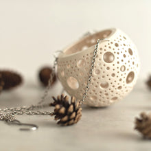 Load image into Gallery viewer, Enjoy this pot as either a planter or a hanging candle holder - the choice is yours! The detailed designs are carved by hand into the pottery and either allow air to circulate to your plant or cast fascinating patterns if you use it as a candle holder!