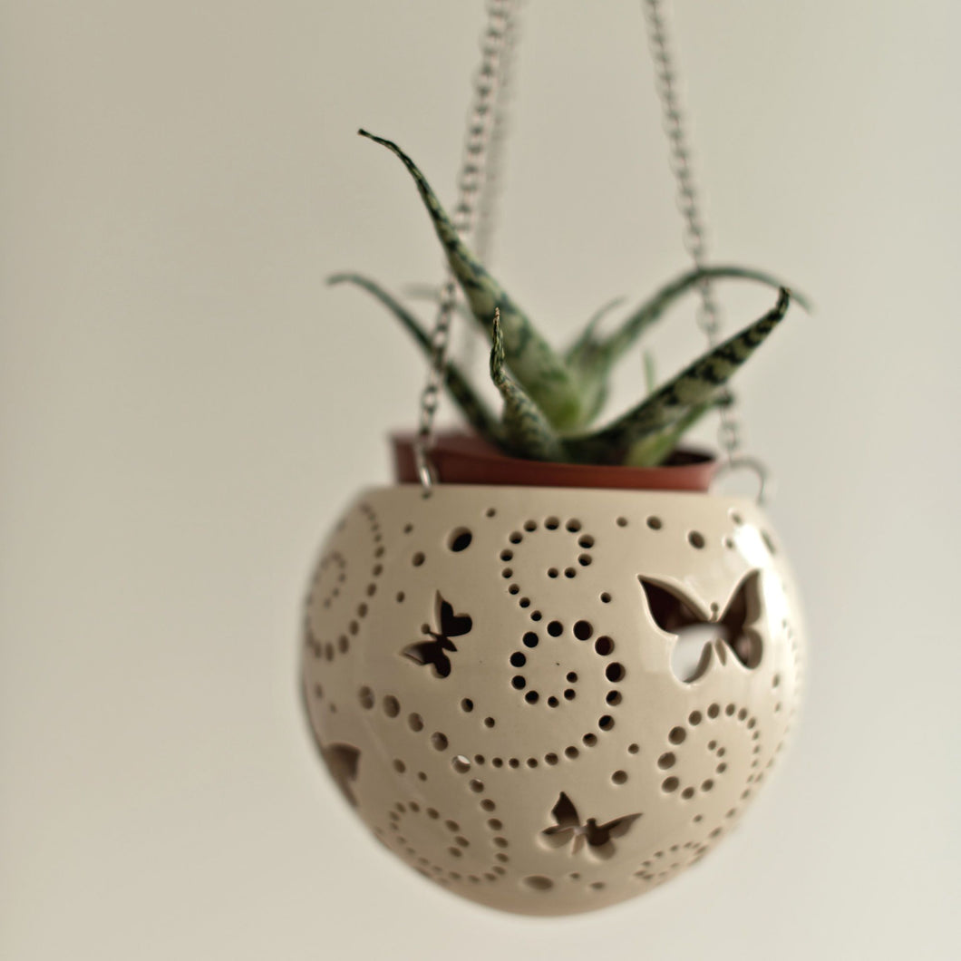 Enjoy this pot as either a planter or a hanging candle holder - the choice is yours! The detailed designs are carved by hand into the pottery and either allow air to circulate to your plant or cast fascinating patterns if you use it as a candle holder!