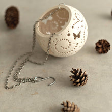 Load image into Gallery viewer, Enjoy this pot as either a planter or a hanging candle holder - the choice is yours! The detailed designs are carved by hand into the pottery and either allow air to circulate to your plant or cast fascinating patterns if you use it as a candle holder!