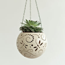 Load image into Gallery viewer, Enjoy this pot as either a planter or a hanging candle holder - the choice is yours! The detailed designs are carved by hand into the pottery and either allow air to circulate to your plant or cast fascinating patterns if you use it as a candle holder!