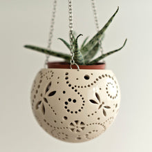 Load image into Gallery viewer, Enjoy this pot as either a planter or a hanging candle holder - the choice is yours! The detailed designs are carved by hand into the pottery and either allow air to circulate to your plant or cast fascinating patterns if you use it as a candle holder!
