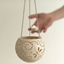 Load image into Gallery viewer, Enjoy this pot as either a planter or a hanging candle holder - the choice is yours! The detailed designs are carved by hand into the pottery and either allow air to circulate to your plant or cast fascinating patterns if you use it as a candle holder!
