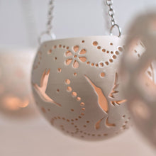 Load image into Gallery viewer, Enjoy this pot as either a planter or a hanging candle holder - the choice is yours! The detailed designs are carved by hand into the pottery and either allow air to circulate to your plant or cast fascinating patterns if you use it as a candle holder!