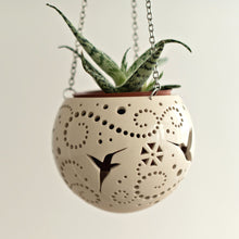 Load image into Gallery viewer, Enjoy this pot as either a planter or a hanging candle holder - the choice is yours! The detailed designs are carved by hand into the pottery and either allow air to circulate to your plant or cast fascinating patterns if you use it as a candle holder!

