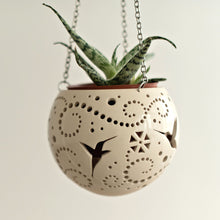 Load image into Gallery viewer, Enjoy this pot as either a planter or a hanging candle holder - the choice is yours! The detailed designs are carved by hand into the pottery and either allow air to circulate to your plant or cast fascinating patterns if you use it as a candle holder!