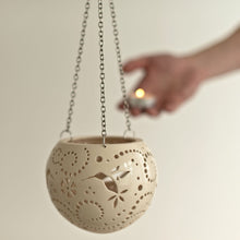 Load image into Gallery viewer, Enjoy this pot as either a planter or a hanging candle holder - the choice is yours! The detailed designs are carved by hand into the pottery and either allow air to circulate to your plant or cast fascinating patterns if you use it as a candle holder!
