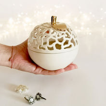 Load image into Gallery viewer, These ceramic bowls with a lid are ideal to use as a vanity jar to keep small valuables safe in the bathroom or bedroom. Ceramic bowls are made from white clay with gold-painted accents and hand-carved cut-outs in the lid.
