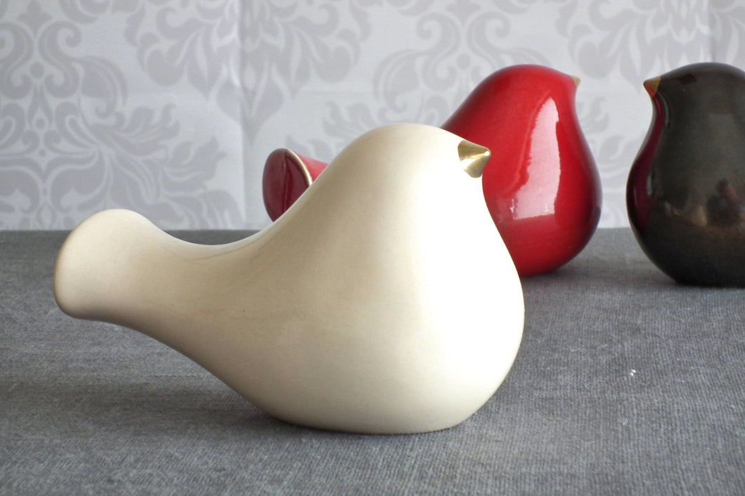 Ceramic bird with a gold beak. This skillfully crafted ceramic bird will look great perched on a shelf, cabinet, or desk. A great statement piece of décor, this ceramic bird will also make a romantic table centerpiece for weddings and other occasions.