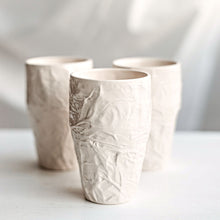 Load image into Gallery viewer, Upgrade your drinkware with these crumpled ceramic tumblers! The tumblers are made from high-quality white clay with a fascinating texture. This ceramic tumbler is perfect for drinking cold beverages like juice, water, milk, soft drinks, and even wine!

