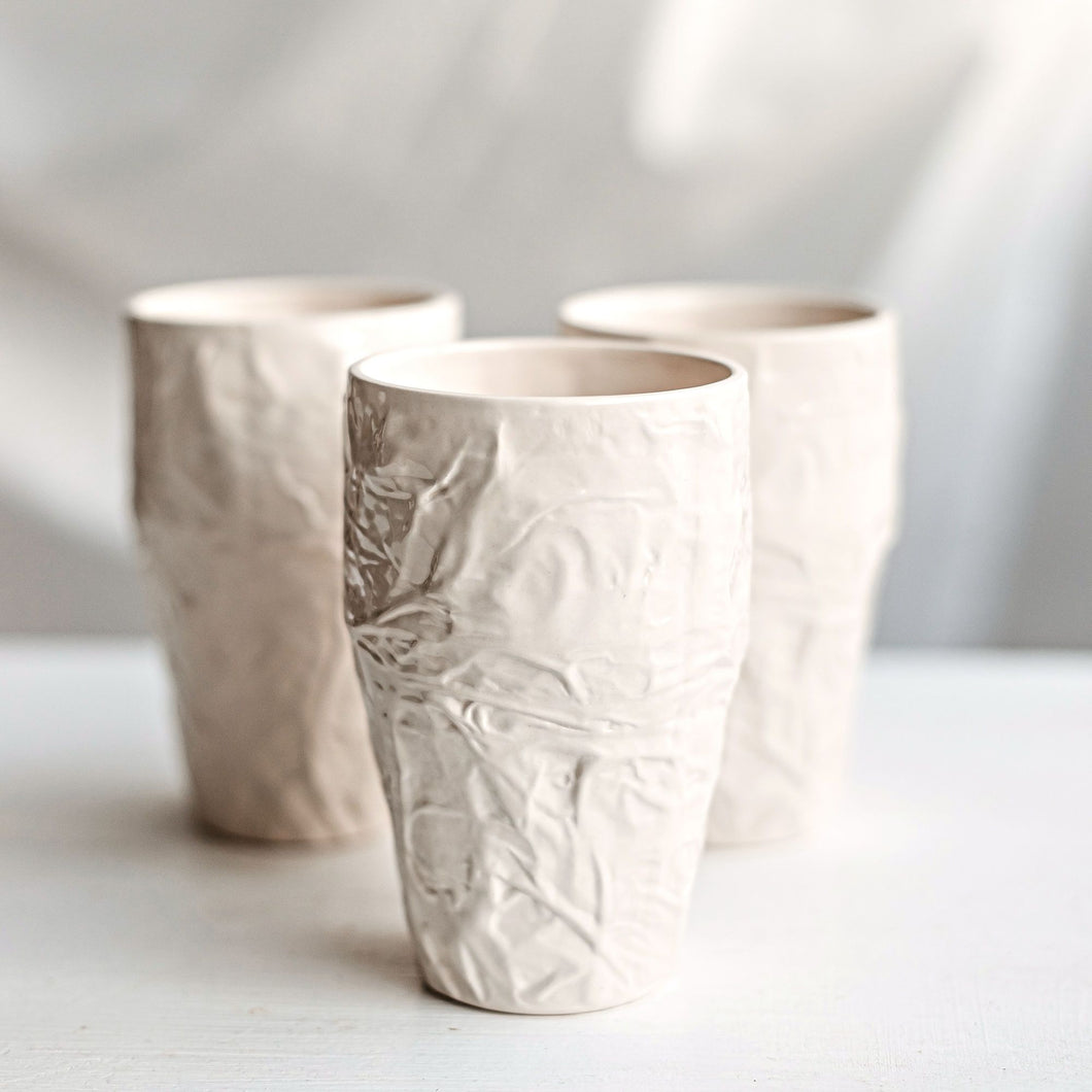 Upgrade your drinkware with these crumpled ceramic tumblers! The tumblers are made from high-quality white clay with a fascinating texture. This ceramic tumbler is perfect for drinking cold beverages like juice, water, milk, soft drinks, and even wine!