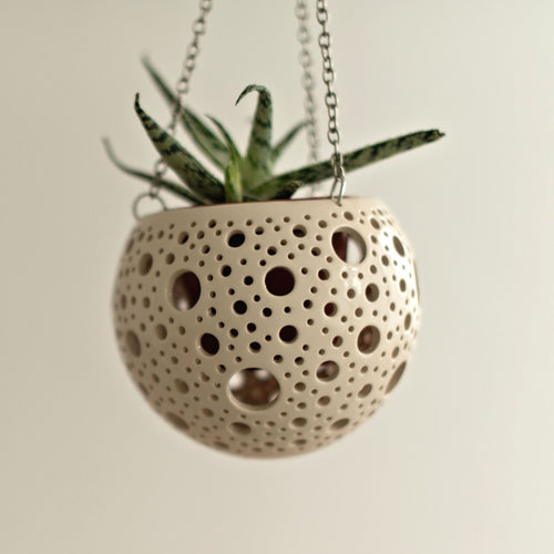 Enjoy this pot as either a planter or a hanging candle holder - the choice is yours! The detailed designs are carved by hand into the pottery and either allow air to circulate to your plant or cast fascinating patterns if you use it as a candle holder!