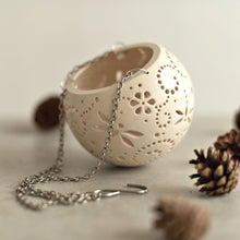 Load image into Gallery viewer, Enjoy this pot as either a planter or a hanging candle holder - the choice is yours! The detailed designs are carved by hand into the pottery and either allow air to circulate to your plant or cast fascinating patterns if you use it as a candle holder!
