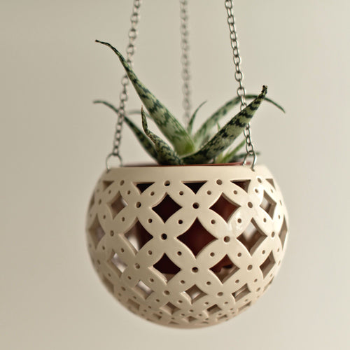 Enjoy this pot as either a planter or a hanging candle holder - the choice is yours! The detailed designs are carved by hand into the pottery and either allow air to circulate to your plant or cast fascinating patterns if you use it as a candle holder!
