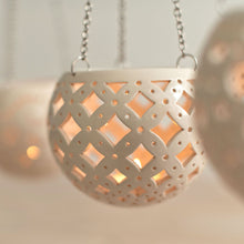 Load image into Gallery viewer, Enjoy this pot as either a planter or a hanging candle holder - the choice is yours! The detailed designs are carved by hand into the pottery and either allow air to circulate to your plant or cast fascinating patterns if you use it as a candle holder!

