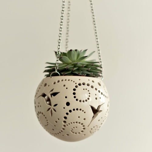 Enjoy this pot as either a planter or a hanging candle holder - the choice is yours! The detailed designs are carved by hand into the pottery and either allow air to circulate to your plant or cast fascinating patterns if you use it as a candle holder!